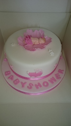 Pink and white baby shower cake with pink lily